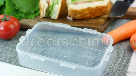女人把新鲜的三明治放进饭盒里视频的预览图