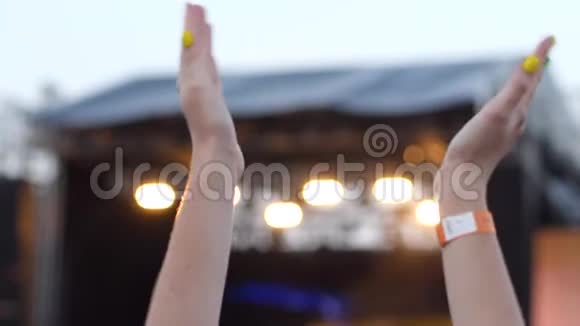 在现场的背景和明亮的闪光灯下鼓掌许多歌迷在露天自由摇滚音乐会上手中的手视频的预览图