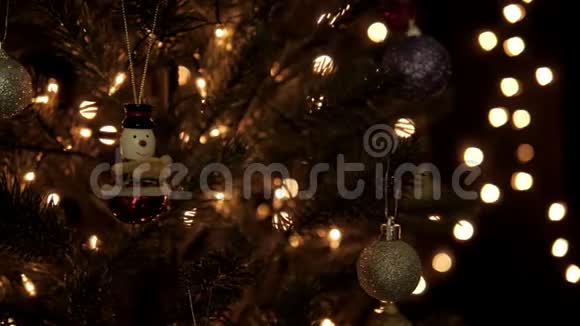 在圣诞节期间圣诞球和雪人装饰在树上并在树上放着灯视频的预览图