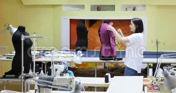 年轻女性时装设计师在工作室工作服装设计师正在研究人体模型视频的预览图