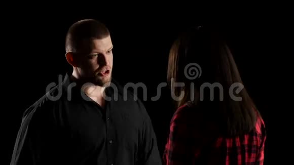 情绪化的男人和女人在黑色背景上说得很烦躁特写视频的预览图
