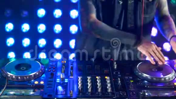 DJ手在DJ甲板上调整轨道控制视频的预览图