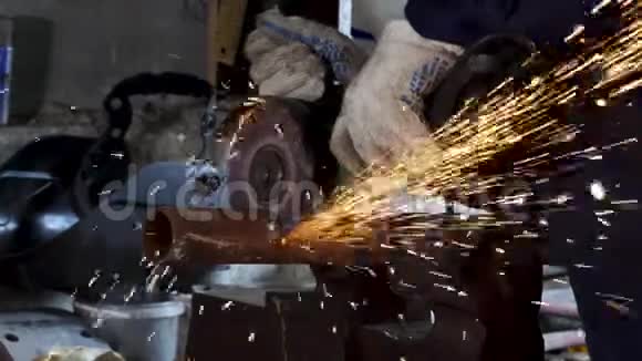 男手用角磨机切断水管片在建筑中切割带有火花的钢视频的预览图