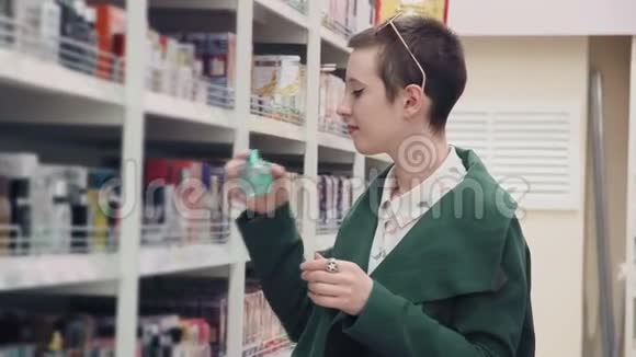 在超市里选择香水的年轻女子视频的预览图