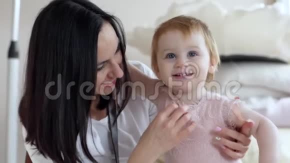 幸福的家庭妈妈带着小女孩微笑着在家里的卧室特写视频的预览图