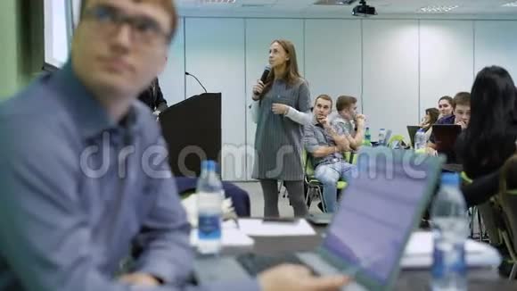 女学生在大学的一个研讨会上用麦克风和投影仪讲话现代课堂教学视频的预览图