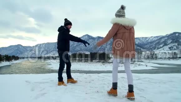 一对年轻夫妇冬天在山上奔跑视频的预览图