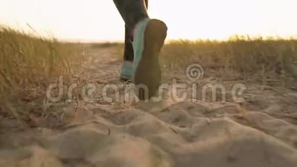 女性的腿沿着沙滩向海洋奔跑慢动作视频的预览图