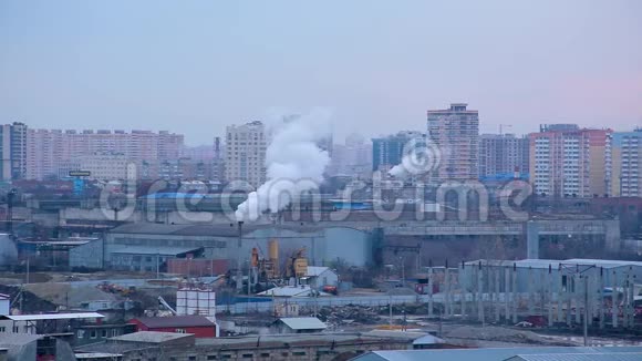 晚城景观高层建筑在建工厂和管道有烟视频的预览图