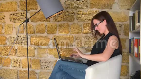 年轻女孩一个拿着笔记本电脑的女商人坐在椅子上拿着台灯学生正在准备考试视频的预览图