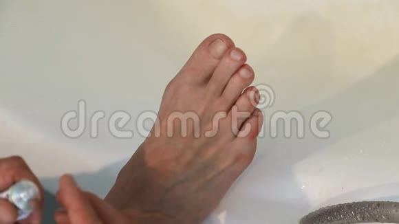 在脚上涂奶油的人男人用保湿霜护理他干燥的脚部皮肤护肤品特写视频的预览图