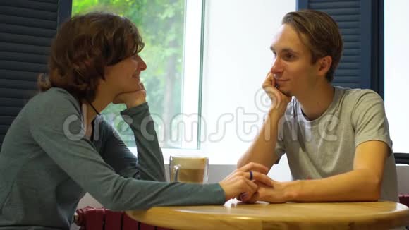 快乐的年轻夫妇在咖啡馆里用地中海风格交谈视频的预览图