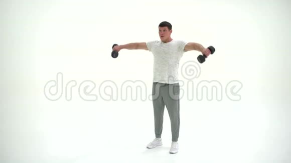 健身运动员男子与哑铃在工作室在白色背景4K视频的预览图