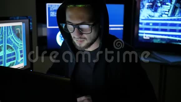 男性黑客在电脑上工作而绿色代码字符反映在黑暗的办公室里网络间谍视频的预览图