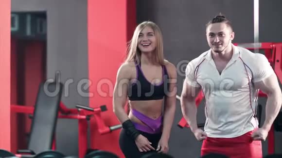 年轻的运动夫妇在健身房锻炼肌肉视频的预览图