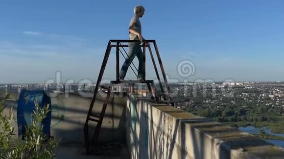 年轻人从高楼上的梯子上欣赏风景视频的预览图