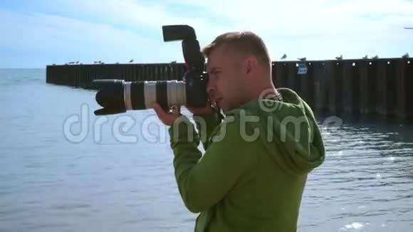 摄影师在海边拍照用相机拉近摄影师的距离视频的预览图