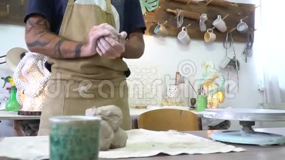 波特在轻盈时尚的陶工工作空间中揉捏一块粘土视频的预览图