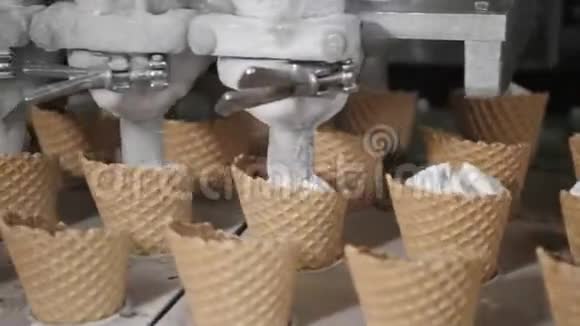 机器人机器自动将冰淇淋倒入晶片杯中用于制冰的输送机自动生产线视频的预览图