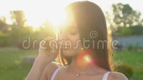 时尚模特女孩在金色闪闪发光的摆姿势一幅美丽的女人在户外用闪光的纸屑描绘视频的预览图