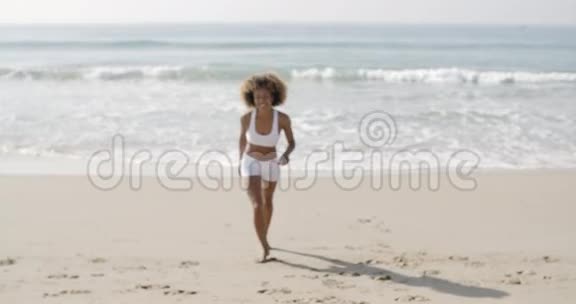 女人在沙滩上奔跑和挥手视频的预览图
