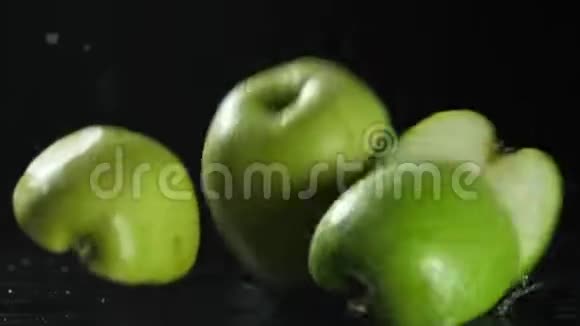 绿色苹果切片落在黑色背景慢动作高清视频的预览图