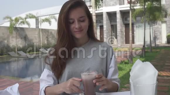 美丽的年轻女子在豪华别墅早餐期间喝可可女人喝热巧克力和期待视频的预览图