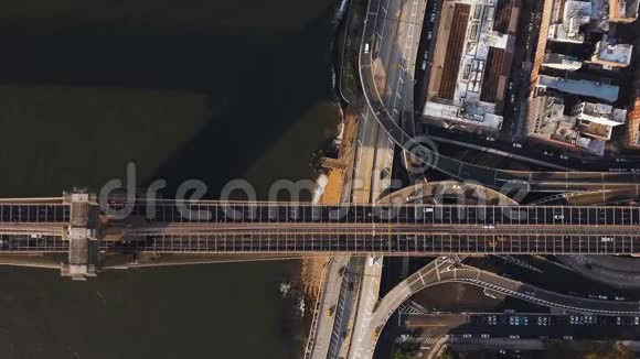 在美国纽约曼哈顿一侧布鲁克林大桥通过东河和公路交叉口的空中俯视视频的预览图