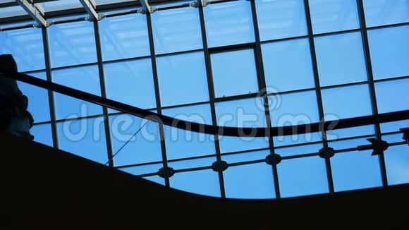 现代玻璃建筑和扶梯上商务人士的移动轮廓视频的预览图