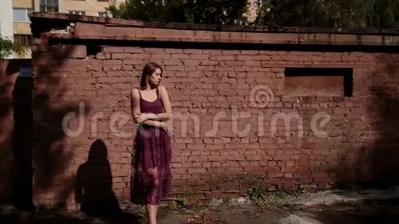 在砖房的老院子里摆姿势的漂亮女孩视频的预览图