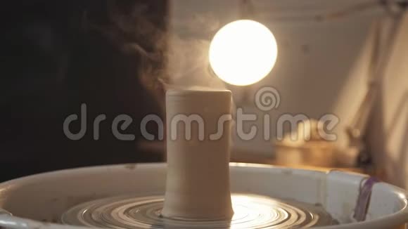 陶器工作室陶工车轮上的粘土制品深色背景视频的预览图