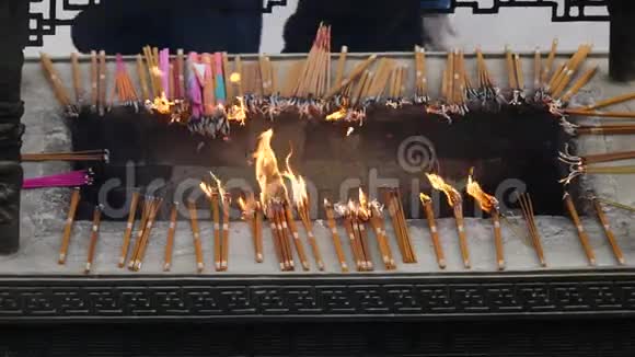 中国传统寺庙的慢火和香烟祈祷者将烧香放入香炉4K视频视频的预览图