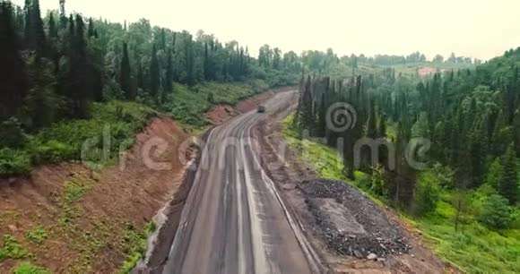森林道路全景林中乡村道路上的倾卸车的鸟瞰图从泰加无人机的视野视频的预览图