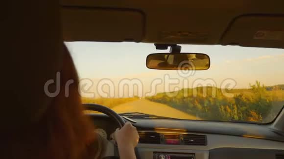 高加索女孩开车经过摇摇欲坠的乡村公路乡村景观秋天的日落视频的预览图