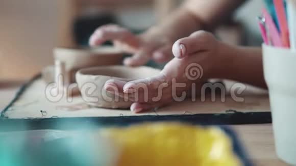 女孩忙于创造性的工作创造一盘粘土的过程女性双手特写视频的预览图