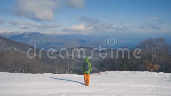 女孩正走在白雪覆盖的森林里徒步旅行冬天的雪景视频的预览图