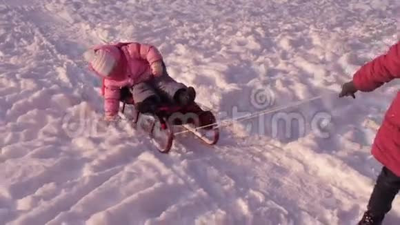 妈妈用雪橇把孩子卷起来视频的预览图