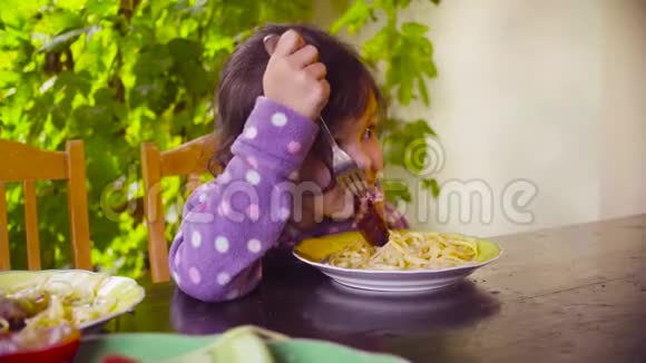 小女孩正坐在桌子旁吃炸香肠视频的预览图