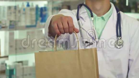 医生微笑着在药店拿着包裹视频的预览图