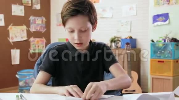 可爱的男孩在他的房间里折叠折纸视频的预览图