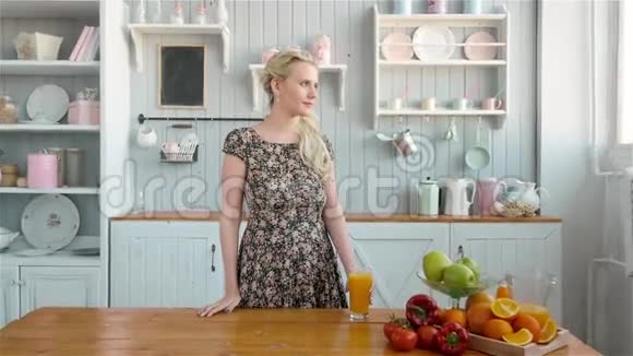 喝橙汁的女人微笑着展示果汁年轻漂亮的白人模特视频的预览图