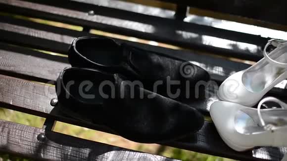 婚礼当天新郎新娘的鞋子放在长凳上视频的预览图