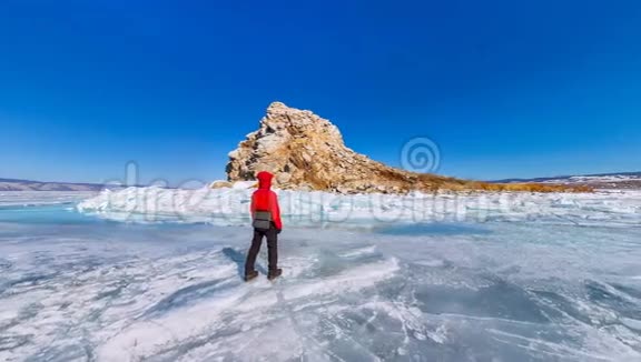 360K全景男子游客站在贝加尔湖蓝色冰层上的亚多尔岛视频的预览图