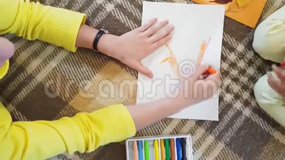年轻的母亲和女儿在白纸上画油浆字秋天做一个贴花小女孩视频的预览图
