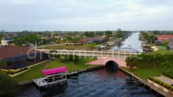 奇妙的4k空中无人机全景景观小热带豪华度假小镇深蓝色平静运河河水视频的预览图