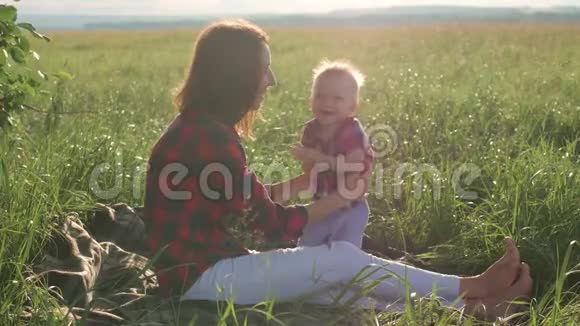 快乐的年轻母亲在阳光温暖的秋日或夏日与她的小儿子玩耍天空中的彩虹快乐视频的预览图