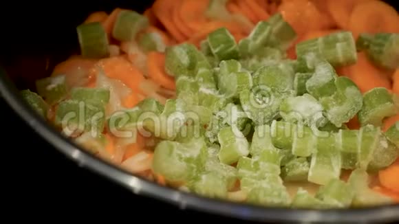 近距离观看新鲜胡萝卜和冷冻蔬菜煎锅砂锅视频的预览图