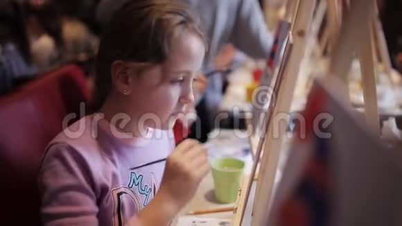 画和画架美术工作室里的一群孩子孩子们在画布上写一幅画视频的预览图