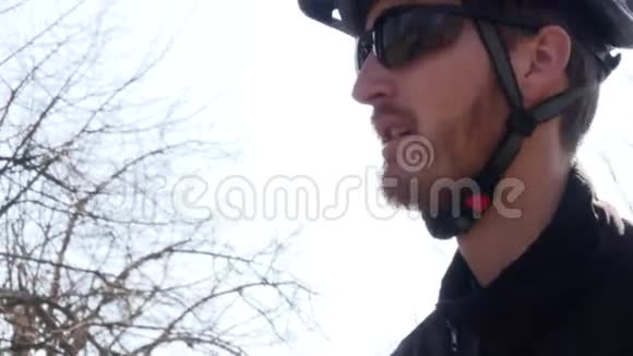 特写一幅严肃而体贴的骑手肖像戴着自行车服防护头盔和眼镜视频的预览图