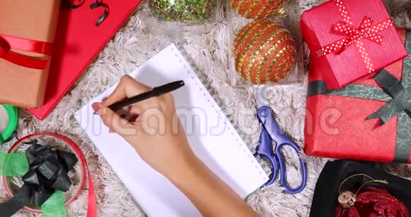 手在记事本上写下圣诞购物清单视频的预览图